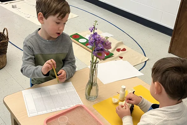 Image of two students work on their projects while have a conversation.